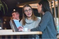 Two Young business women talking with each other about new projects at a coffee bar at caffe brake Royalty Free Stock Photo