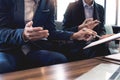 Two young businessmen partner explaining information and pointing at report data discussing strategy agreement or contract at Royalty Free Stock Photo