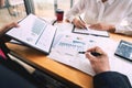 Two young businessmen partner explaining information and pointing at report data discussing strategy agreement or contract at Royalty Free Stock Photo