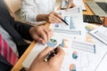 Two young businessmen partner explaining information and pointing at report data discussing strategy agreement or contract at Royalty Free Stock Photo