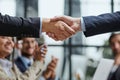 Handshake in agreement against young business people in board room meeting Royalty Free Stock Photo