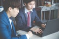 Two young businessmen using laptop at meeting Royalty Free Stock Photo