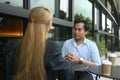 Two young businesspeople having a conversation at an outdoor cafe Royalty Free Stock Photo