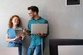 Two young businesspeople using a digital tablet while standing in a boardroom.