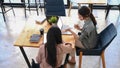 Two young businesswoman analyzing financial report and working with laptop computer in modern office.