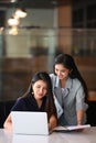 Two young businesswoman giving some new ideas about new project on laptop computer to her partners in office.