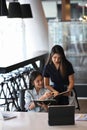 Two young businesswoman using digital tablet and discussing business plan at modern office building. Royalty Free Stock Photo