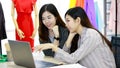 Two young businesswomen colleagues in working office style clothes looking at laptop computer screen together with happy action. Royalty Free Stock Photo