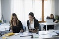 Two businesswomen reading financial document together at a boardroom. Royalty Free Stock Photo