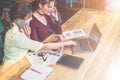 Two young businesswomen are sitting at table, talking on cell phone and using laptop. Royalty Free Stock Photo