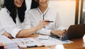 Two young businesswomen working new start up project Laptop computer and digital tablet and smart phone and discussing business Royalty Free Stock Photo