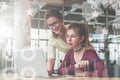 Two young businesswomen working together in office.One girl is sitting at table in front of laptop. Royalty Free Stock Photo