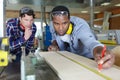 Two young carpenters working in shop