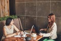 Two young caucasian businesswomen with laptop, notebook. Women in cafe Royalty Free Stock Photo