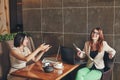 Two young caucasian businesswomen with laptop, notebook. Women in cafe Royalty Free Stock Photo