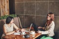 Two young caucasian businesswomen with laptop, notebook. Women in cafe Royalty Free Stock Photo