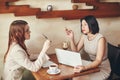 Two young caucasian businesswomen with laptop, notebook. Women in cafe Royalty Free Stock Photo