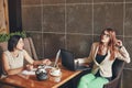 Two young caucasian businesswomen with laptop, notebook. Women in cafe Royalty Free Stock Photo