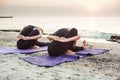 Two young caucasian females practicing yoga on beach Royalty Free Stock Photo