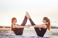 Two young caucasian females practicing yoga on beach Royalty Free Stock Photo