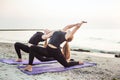 Two young caucasian females practicing yoga on beach Royalty Free Stock Photo