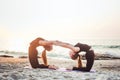 Two young caucasian females practicing yoga on beach Royalty Free Stock Photo