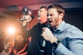 Emotional young guys in karaoke bar Royalty Free Stock Photo