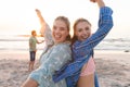 Two young Caucasian women are enjoying a beach sunset, with copy space