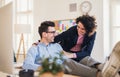 Two young cheerful businesspeople in a modern office, feet on desk. Royalty Free Stock Photo