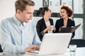 Two young cheerful female employees talking in the office