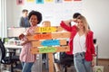 Two young cheerful female office worker are posing for a photo and promoting company slogans in the office. Employees, job, office Royalty Free Stock Photo