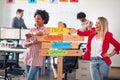 Two young cheerful female office worker are promoting company slogans while posing for a photo in the office. Employees, job, Royalty Free Stock Photo