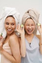 Two cheerful girls posing with cucumber slices isolated over white background Royalty Free Stock Photo