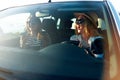 Two young cheerful smiling women in a car on vacation trip to the sea beach. Girl in glasses driving a vehicle from Royalty Free Stock Photo
