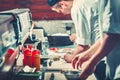 Two young chefs in white uniform preparing sushi