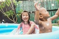 two young children cheerful playing in the outdoor pool on a hot sunny day.