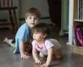 Two young children crawling on the floor