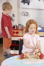 Two Young Children Playing Together at Montessori/ Royalty Free Stock Photo