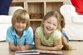 Two Young Children Reading Book at Home