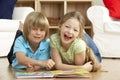 Two Young Children Reading Book at Home Royalty Free Stock Photo