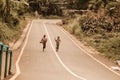 Two young children running barefoot in a street.