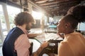 Two young colleagues, male and female, different race, working together in the office, talking, smiling Royalty Free Stock Photo