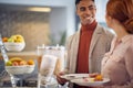 Two young colleagues are talking while helping themselves with a food at the lunch break during a business conference. Business, Royalty Free Stock Photo