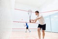 Two young, concentrated and sportive men, friends playing squash together on squash court. Exercising and leisure Royalty Free Stock Photo