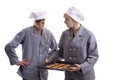 Two young cooks inspecting cookies on a plate Royalty Free Stock Photo