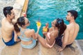 Two young couples drinking cocktails while relaxing together at the pool Royalty Free Stock Photo