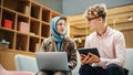 Two Young Creative Colleagues Discussing Work Project and Pointing at the Laptop screen in Office Royalty Free Stock Photo