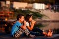 Two young cute boy and girl eating sandwiches and fishing on a lake in a sunny summer day Royalty Free Stock Photo