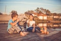 Two young cute little friends, boy and girl eating sandwiches, talking and fishing on a lake in a sunny summer day Royalty Free Stock Photo