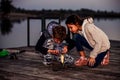 Two young cute little friends, boy and girl fishing on a lake in the evening Royalty Free Stock Photo